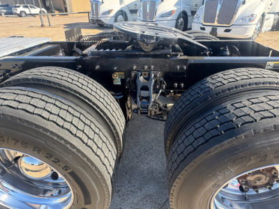 Peterbilt 579 truck chassis showing dual rear axles and driveline components with tires and suspension in view.