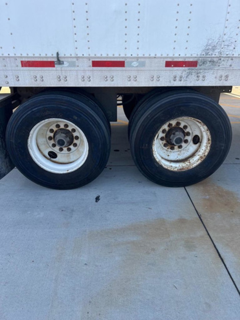 Trailer wheels of a used 2014 utility van showing dual rear axles with white rims and black tires; stock number U91088, VIN 1UYVS2538EP941503 visible on listing.