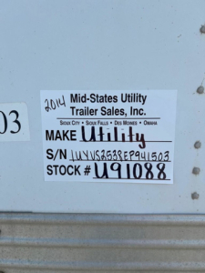 Sticker label on utility trailer showing 2014 Mid-States Utility Trailer Sales, Inc. MAKE Utility, S/N J... STOCK # U91088