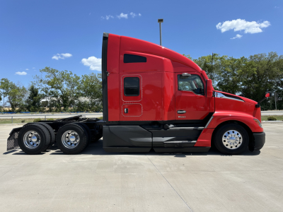 Kenworth T680 sleeper cab truck side view showing red exterior and dual rear axles.