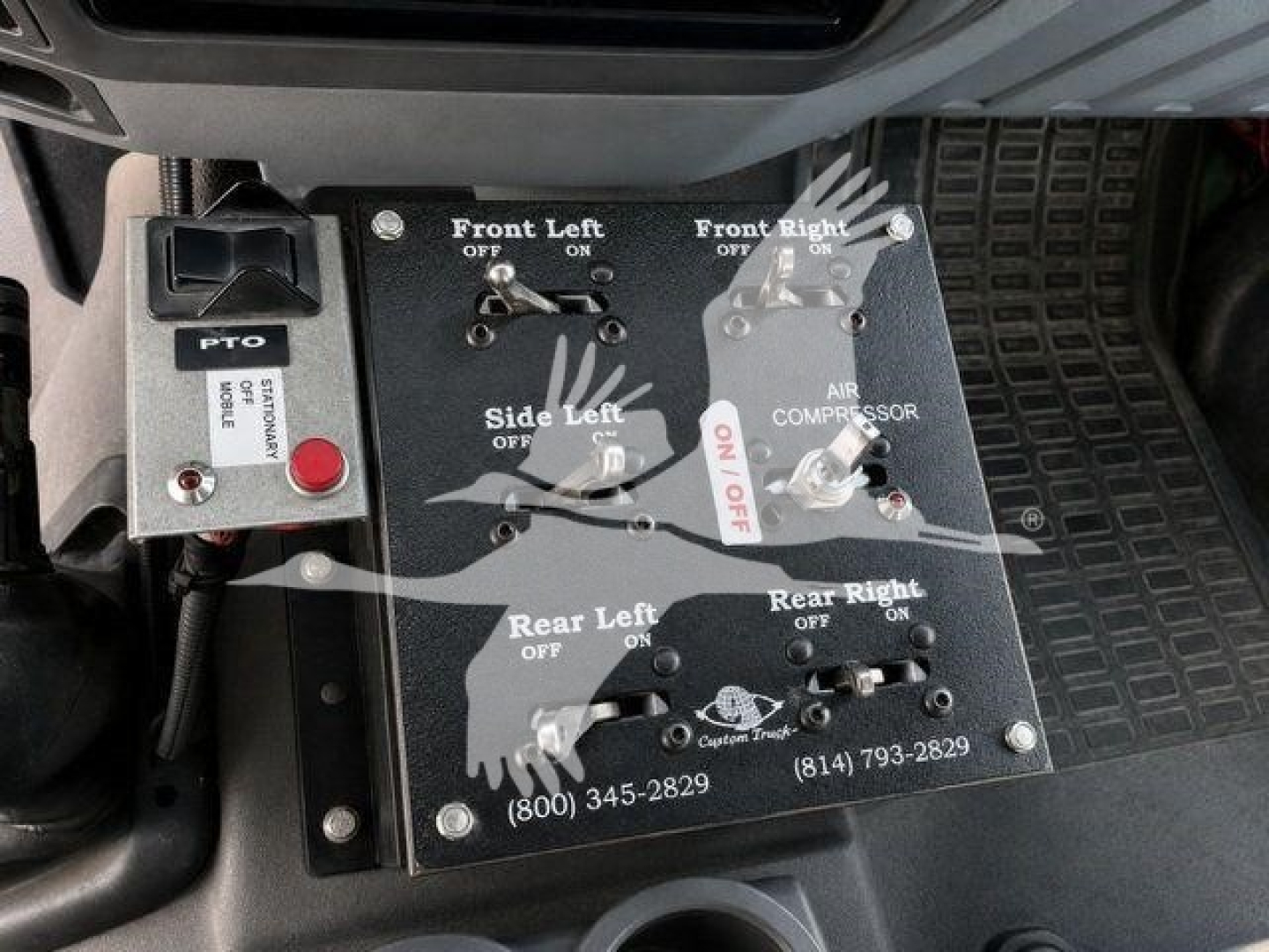 Panel with labeled switches and levers for front left, front right, side left, rear left, and rear right on a control console in a truck cab. Labels include OFF/ON positions and components like AIR COMPRESSOR, with contact numbers and a PTO