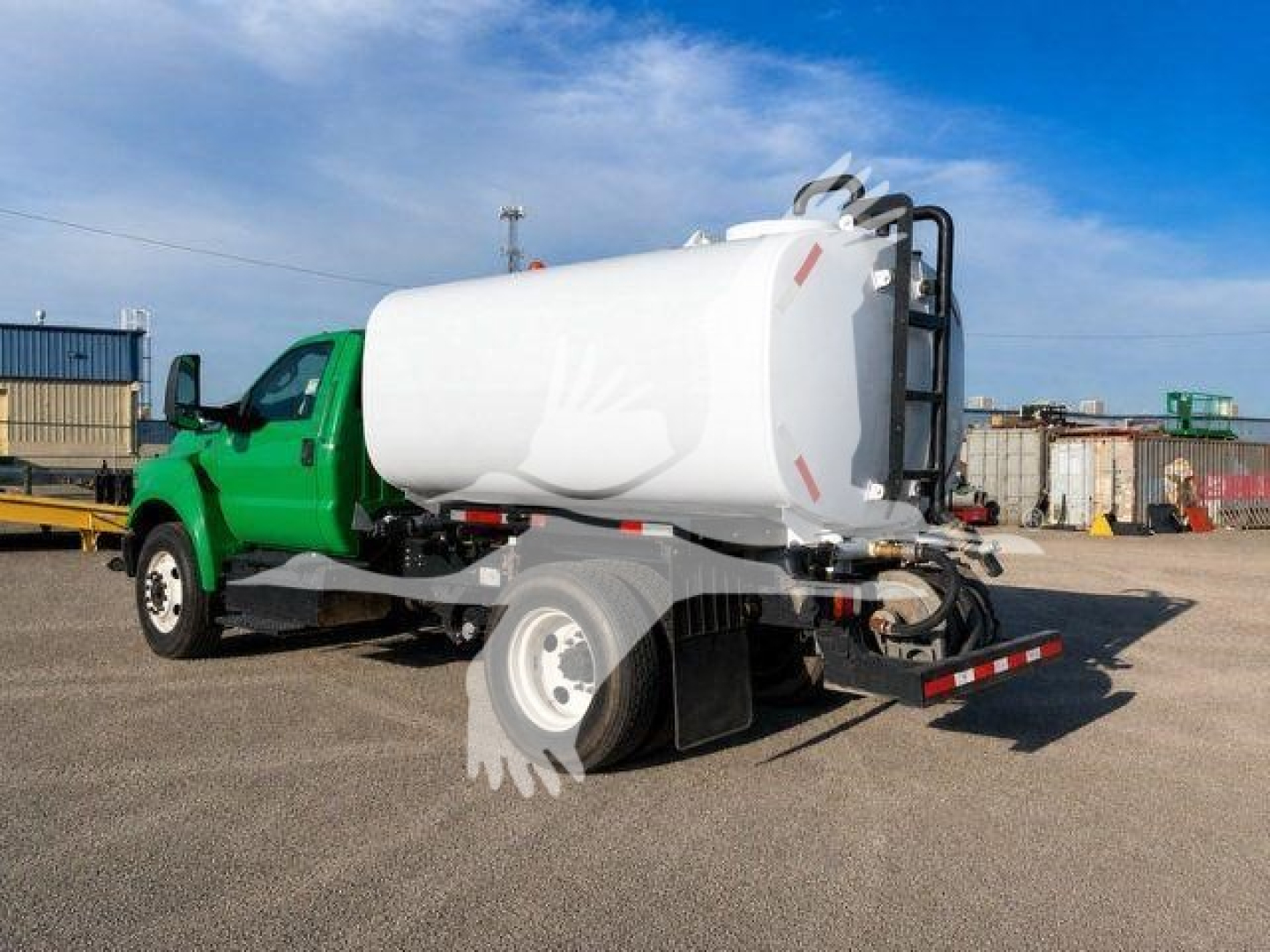 Truck-mounted liquid tanker on a green Ford F-650 XL SD chassis, rear view showing large cylindrical tank and hose reel.