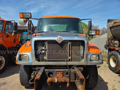 Front view of a 2006 International 7400 cab and chassis showing radiator and front hitch assembly with orange cab and headlights.