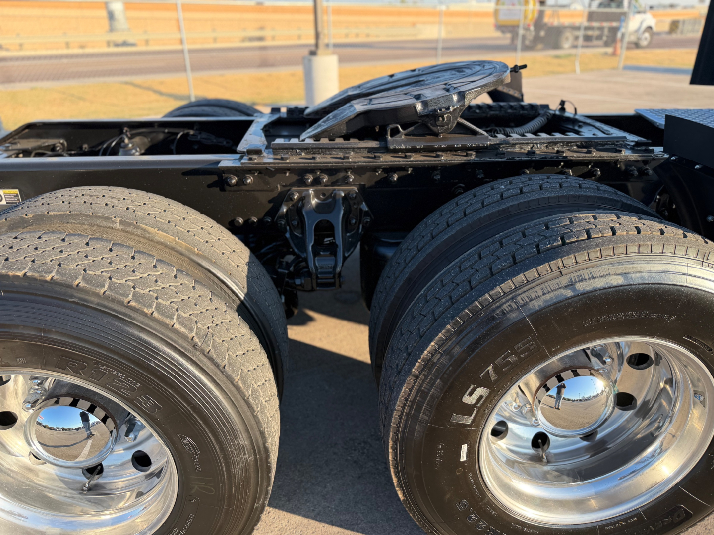 Kenworth W900L truck rear dual rear axles showing tandem drive tires and chrome rims.