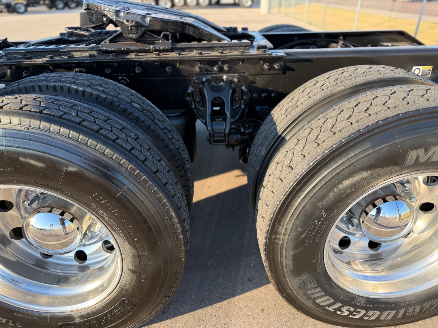 Kenworth W900L truck rear dual tires and chassis rails with chrome hubs.