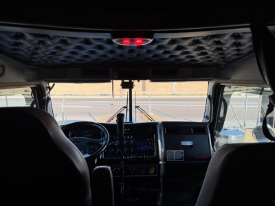 Kenworth W900L dashboard and windshield view from cab showing steering wheel and instrument panel