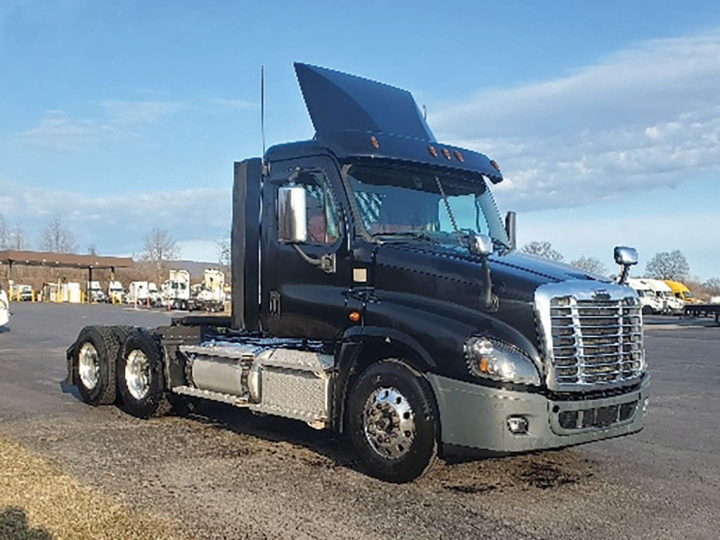 Truck tractor in a Daycab configuration showing a raised hood and Freightliner grille, fuel tanks on the side, and a raised sleeper area with a visible exhaust stack.