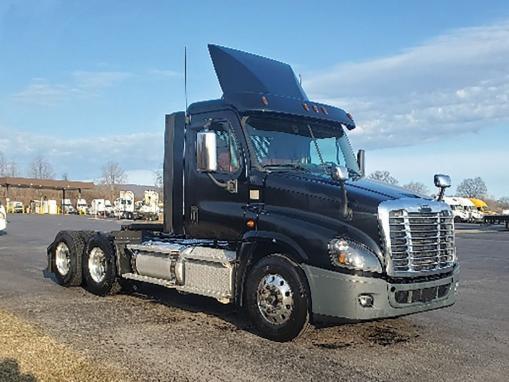 Truck tractor in a Daycab configuration showing a raised hood and Freightliner grille, fuel tanks on the side, and a raised sleeper area with a visible exhaust stack.