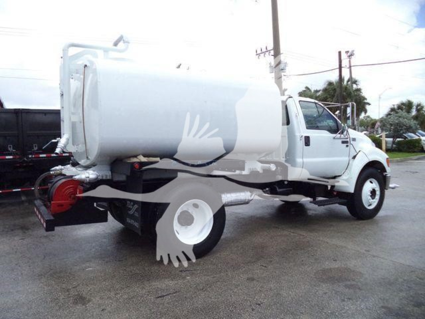 2015 Ford F650 SD truck with a large white tank, side view showing rear tank and dual rear wheels; no legible model text visible.