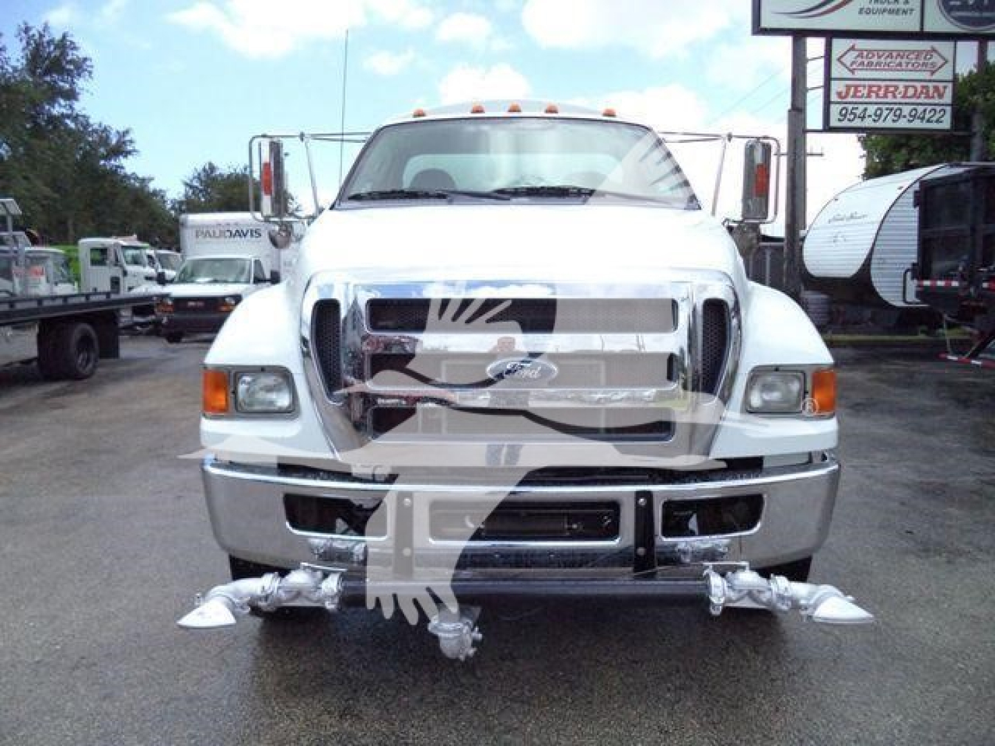 Ford F-650 front view showing chrome grille, bumper, and attached tow hooks with chrome pins.