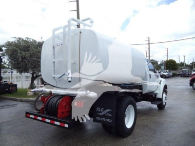 Ford F650 truck with a large rear tank, side view showing water tanker setup and hose reel, rear bumper, and dual rear wheels.