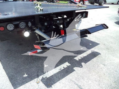 Trailer hitch and rear of 2024 Ram 5500 rollback with hydraulic hoist and control gauges visible.