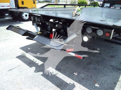 Ram 5500 rollback tow truck rear platform with diamond plate deck and dual stairs, gauges and lights along the side, VIN and stock number not visible in text