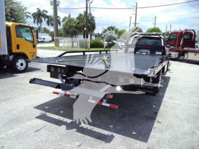 Ram 5500 rollback tow truck bed with flatbed and rear ramps, visible stock number J36635, 2024 Ram 5500 SLT in new condition.