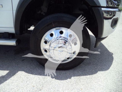 Wheel of a white Ram 5500 truck with chrome hubcap and visible tire, front wheel well and part of the bumper.