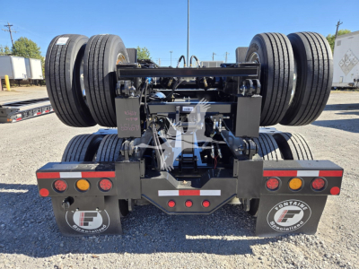 Trailer rear view showing dual axles with hydraulic flip axle mechanism and taillights; Fontaine branding plates on mud flaps with F logo.