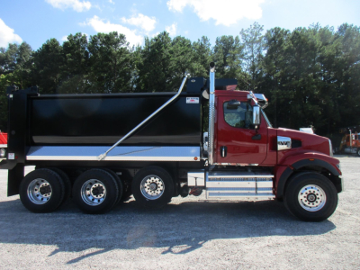Western Star 49X dump truck side view showing red cab and large black dump body.