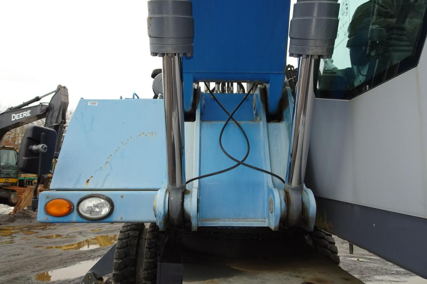 Terex MHL 331 front view showing blue overhead structure, hydraulic cylinders, and front hitch area.