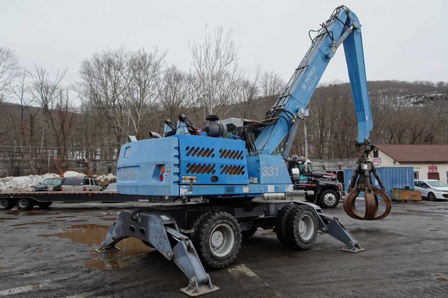 Terex MHL 331 mobile crane in service platform showing hydraulic Boom with grapple and stabilizers extended on muddy lot.