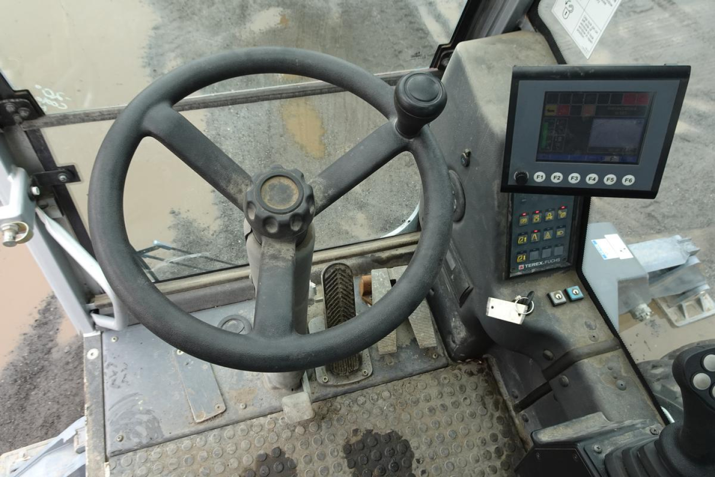 Operator cabin of a 2012 Terex MHL 331 with steering wheel, control monitor, and control panel visible.