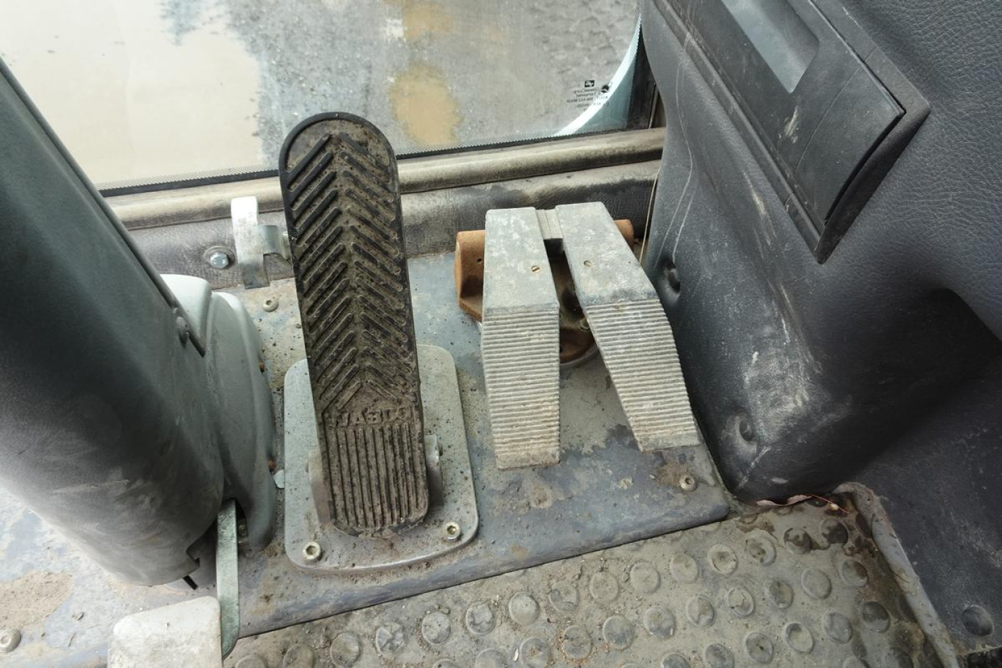 Pedals and foot controls in cab of 2012 Terex MHL 331 showing accelerator and two brake/clutch pedals with rubber surface and surrounding metal plate.