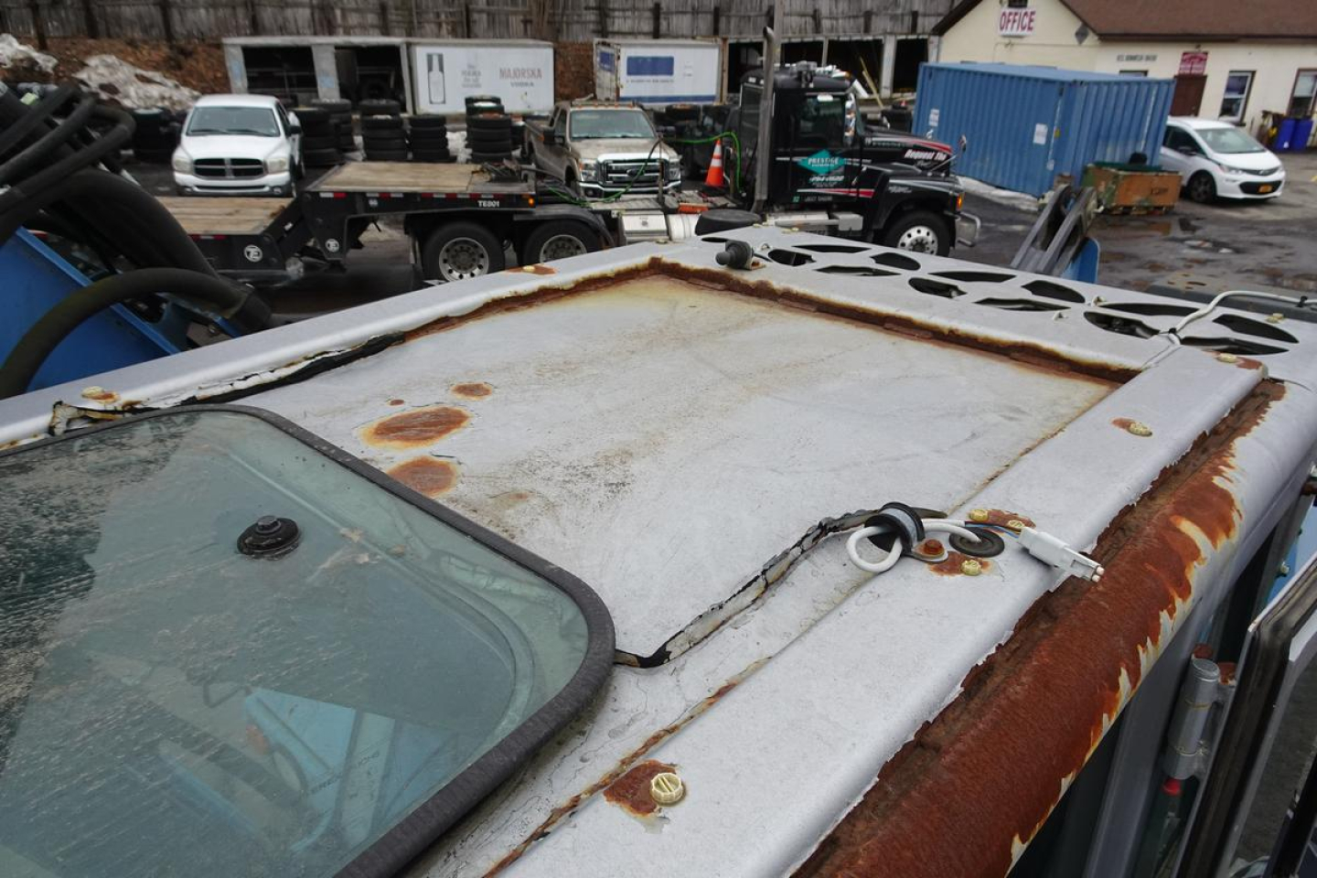 Roof hatch area of a Terex MHL 331 truck showing rusted metal hatch surface and surrounding cab roof edge.