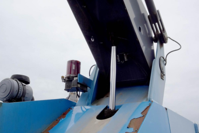 Terex MHL 331 truck-mounted crane component showing hydraulic piston and red beacon light on blue machinery.