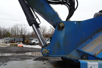 Terex MHL 331 hydraulic arm and joint with blue metal structure and black hydraulic cylinders in view.