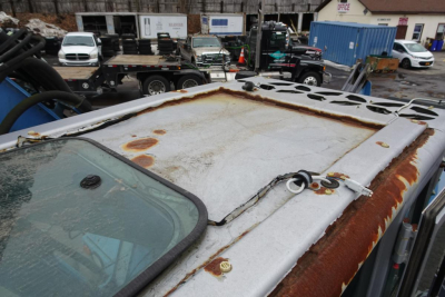Roof hatch area of a Terex MHL 331 truck showing rusted metal hatch surface and surrounding cab roof edge.