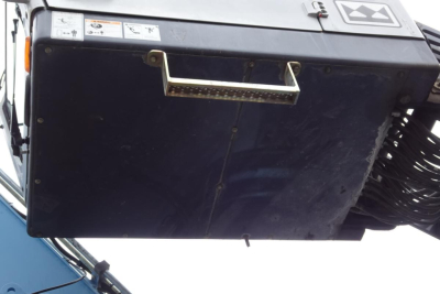 Truck equipment console with handle and stickers on top; black metal box with small labels and white logo at top right.