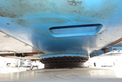 Low-angle view of a blue Terex MHL 331 undercarriage showing wheel hub and rotating mechanism.