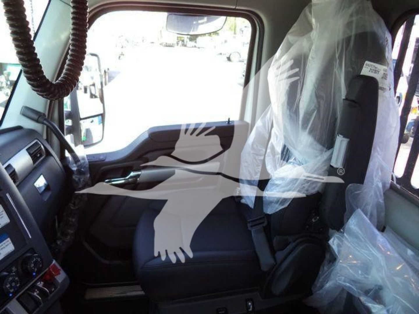 Kenworth T880 truck cab interior view with plastic seat coverings and dashboard controls visible.
