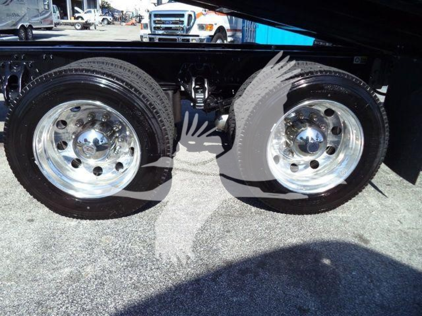 Kenworth T880 rollback truck dual rear wheels chrome rims undercarriage view showing tandem axle and suspension.