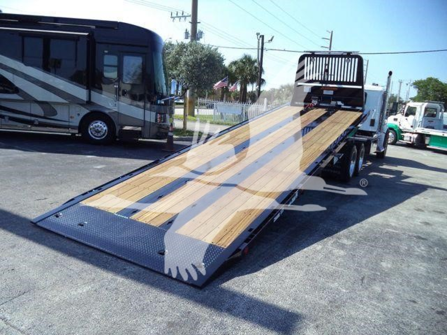 Powerful flatbed tow truck with wooden ramp extended, Kenworth T880 chassis visible, no license plates.