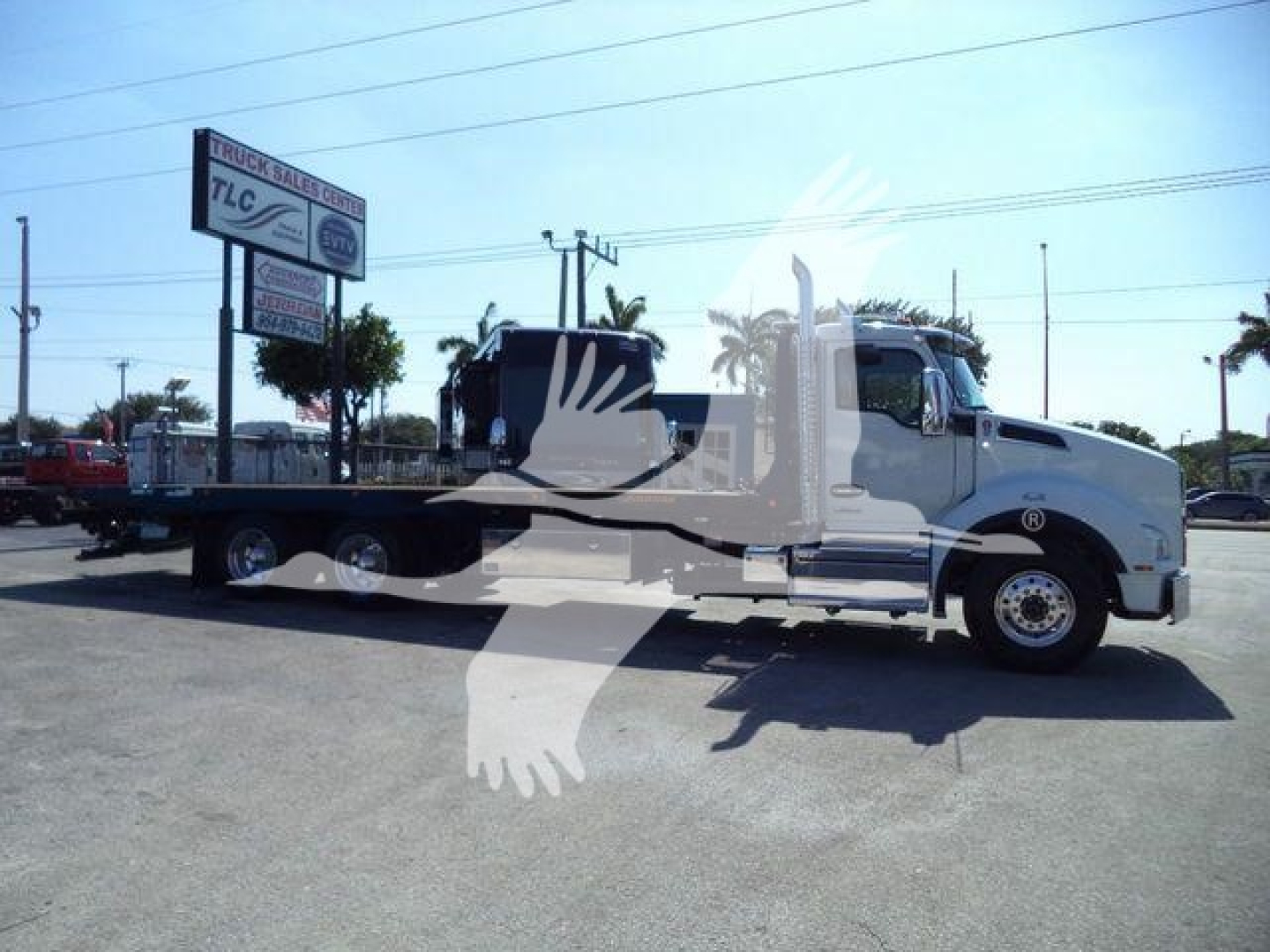 Kenworth T880 rollback tow truck in light color with flatbed, side view showing cab and chassis.