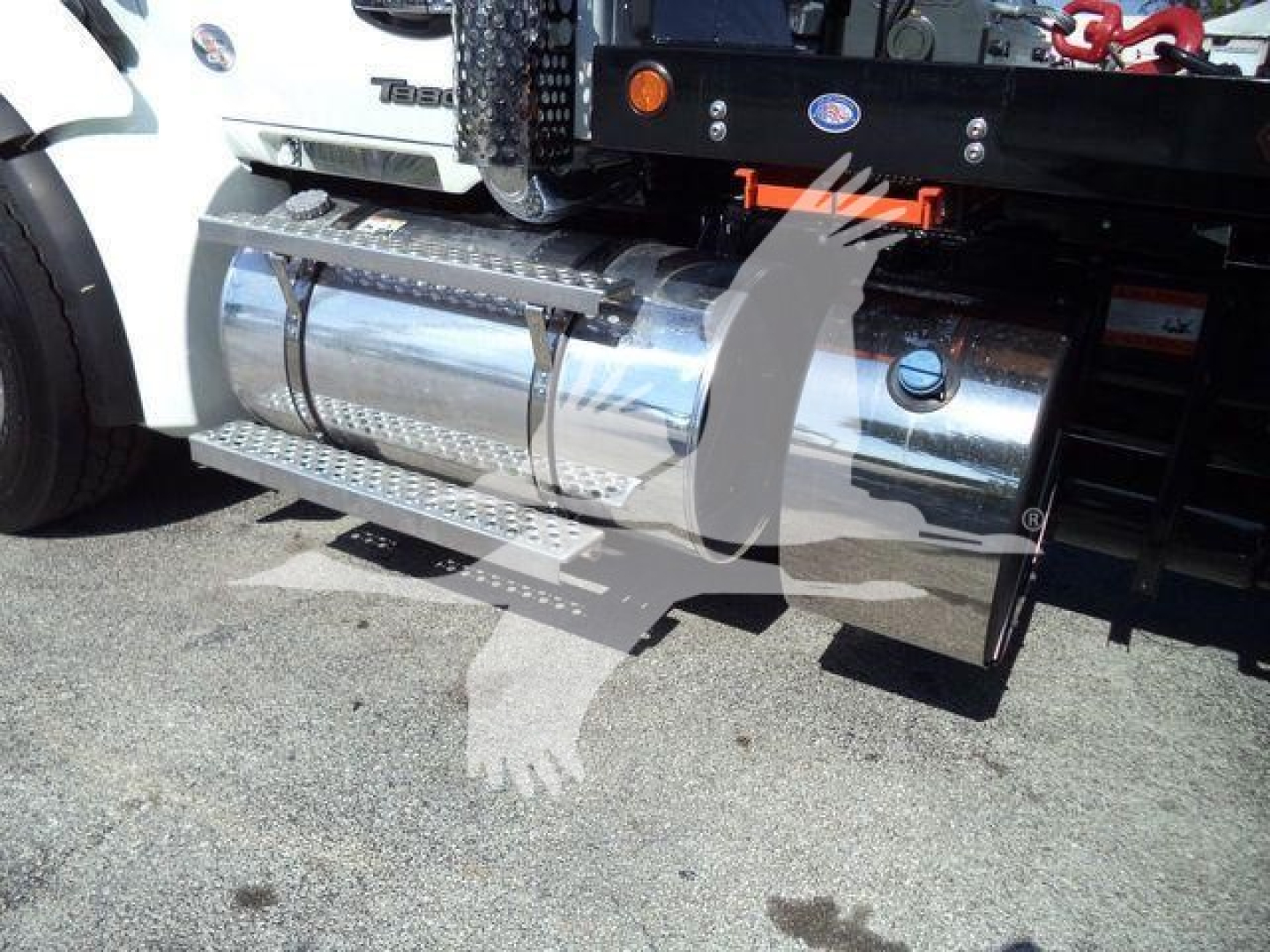Kenworth T880 fuel tank and side steps seen on a rollback truck with chrome cylindrical fuel tanks and aluminum side steps.