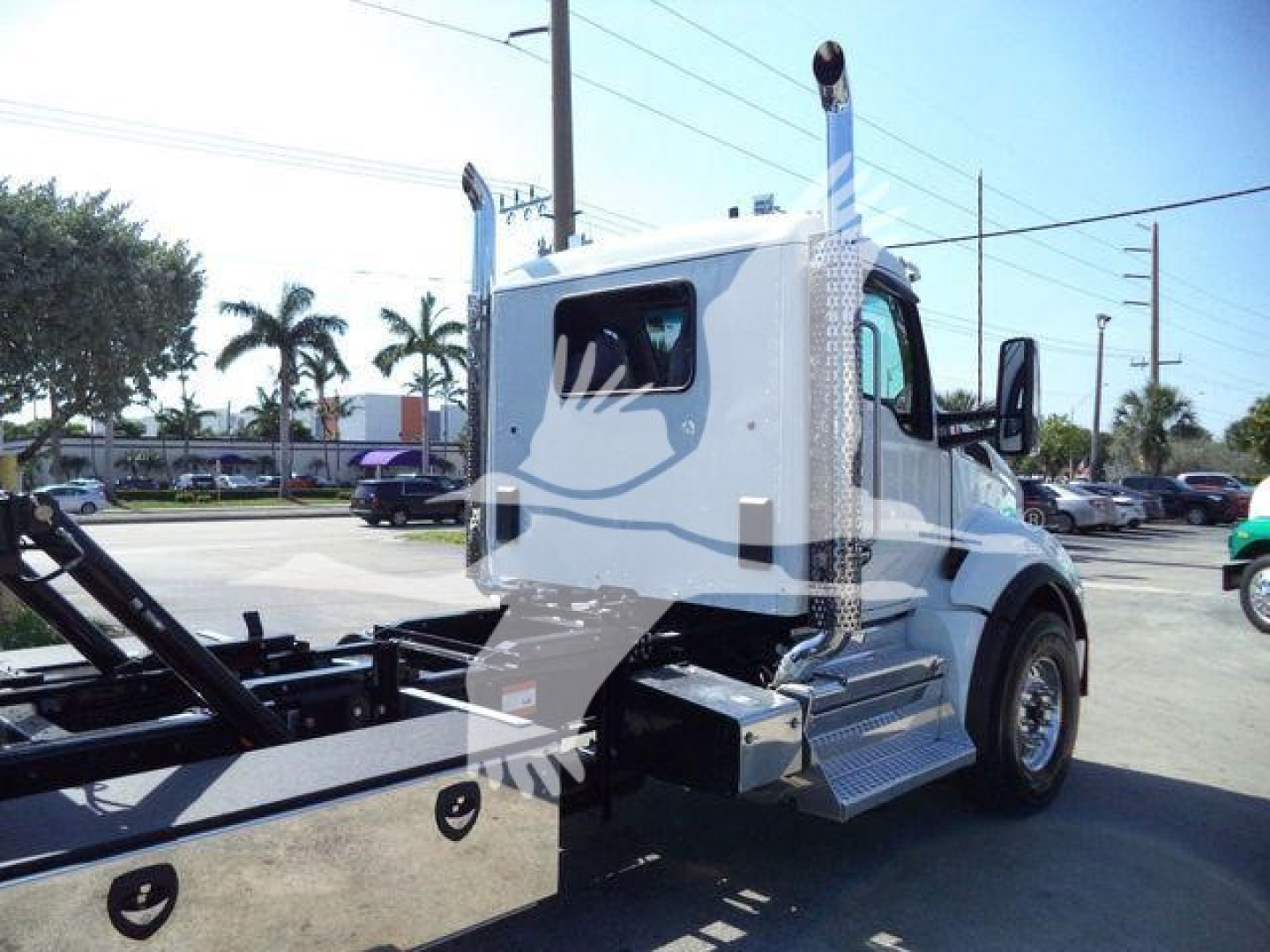 Kenworth T880 roll-back truck cab and chassis with chrome side steps and tall vertical exhaust stacks, white cab, in-yard photo.