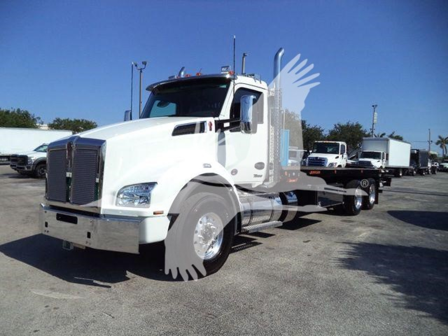 Front-left angle view of a white 2026 Kenworth T880 rollback truck with sleeper cab and chrome wheels.
