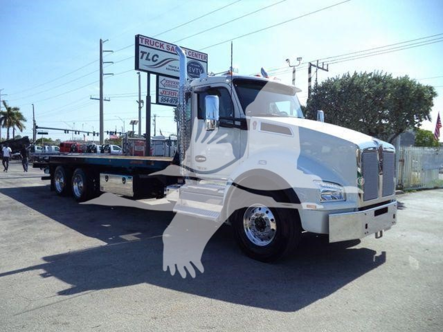 Kenworth T880 rollback truck shown in side/front angle with white cab and flatbed, stock number J68214, no visible text aside from dealership signs.