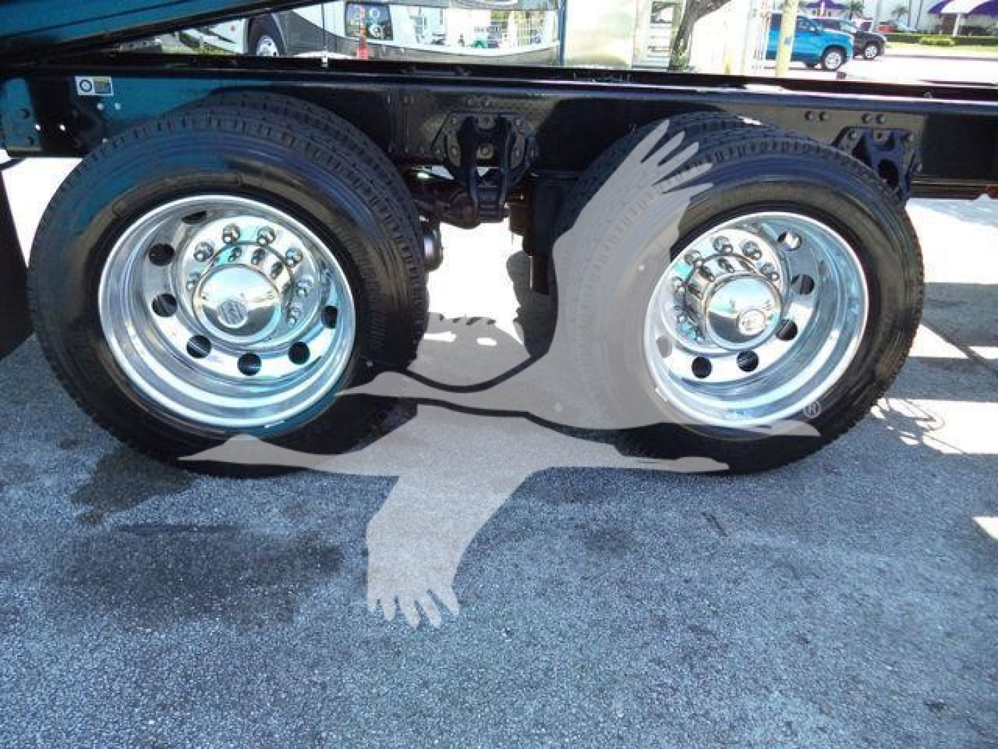 Kenworth T880 rollback truck rear dual wheels showing chrome rims and tires with visible suspension components.