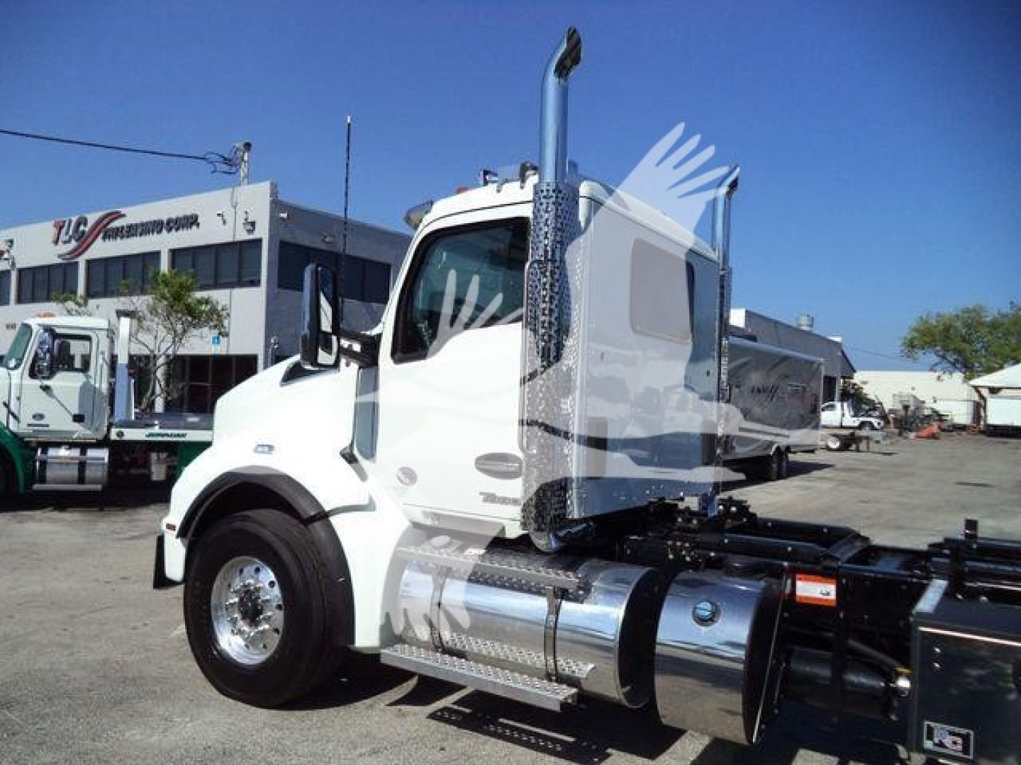 Kenworth T880 heavy-duty truck cab and fuel tanks in a dealership lot; no visible model text on cab in this view.