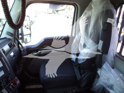 Kenworth T880 truck cab interior view with plastic seat coverings and dashboard controls visible.