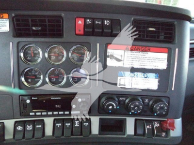 Kenworth T880 dashboard view showing multiple gauges, control switches, and warning labels.