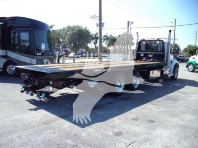 Kenworth T880 flatbed rollback truck showing rear and side view with platform and dual rear axles.
