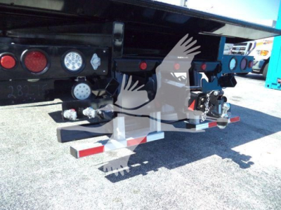 Back of a new Kenworth T880 rollback truck showing rear bumper hardware, mounting brackets, and hydraulic lines.