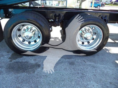 Kenworth T880 rollback truck rear dual wheels showing chrome rims and tires with visible suspension components.