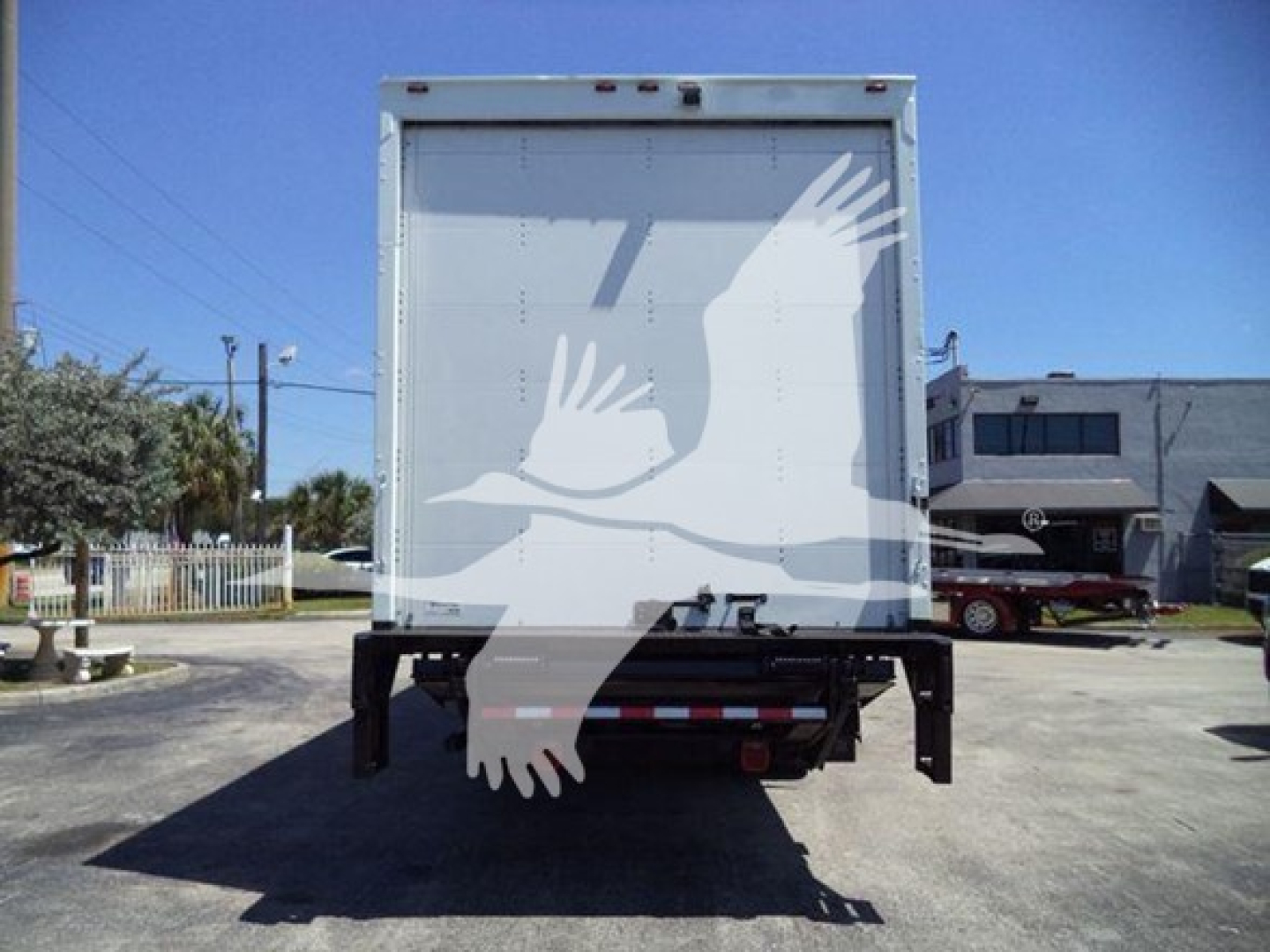 Truck rear view of a Freightliner M2 106 box truck showing back doors and bumper.