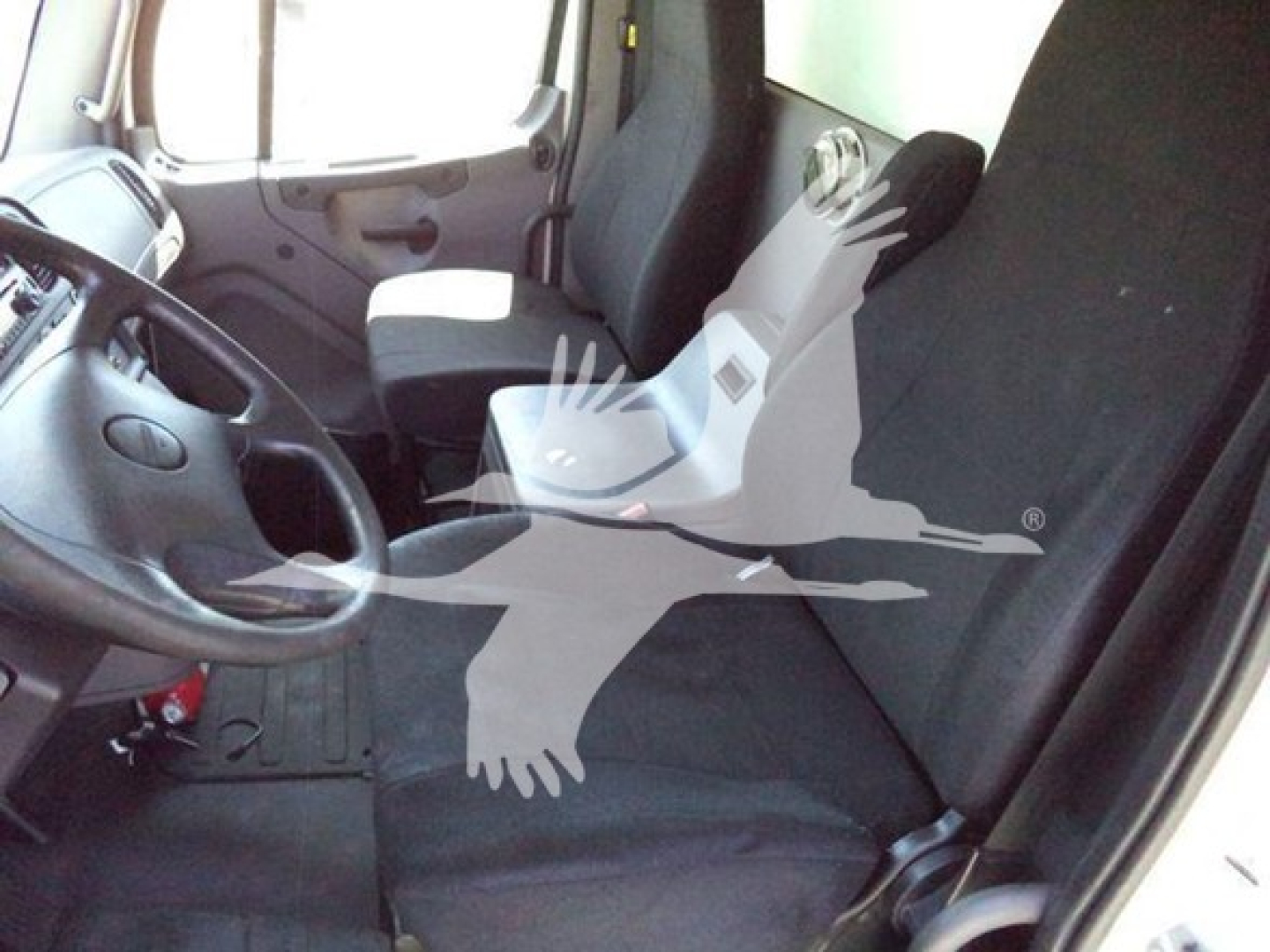 Cab interior of a 2018 Freightliner M2 106 truck showing steering wheel, driver seat, and front passenger seat.