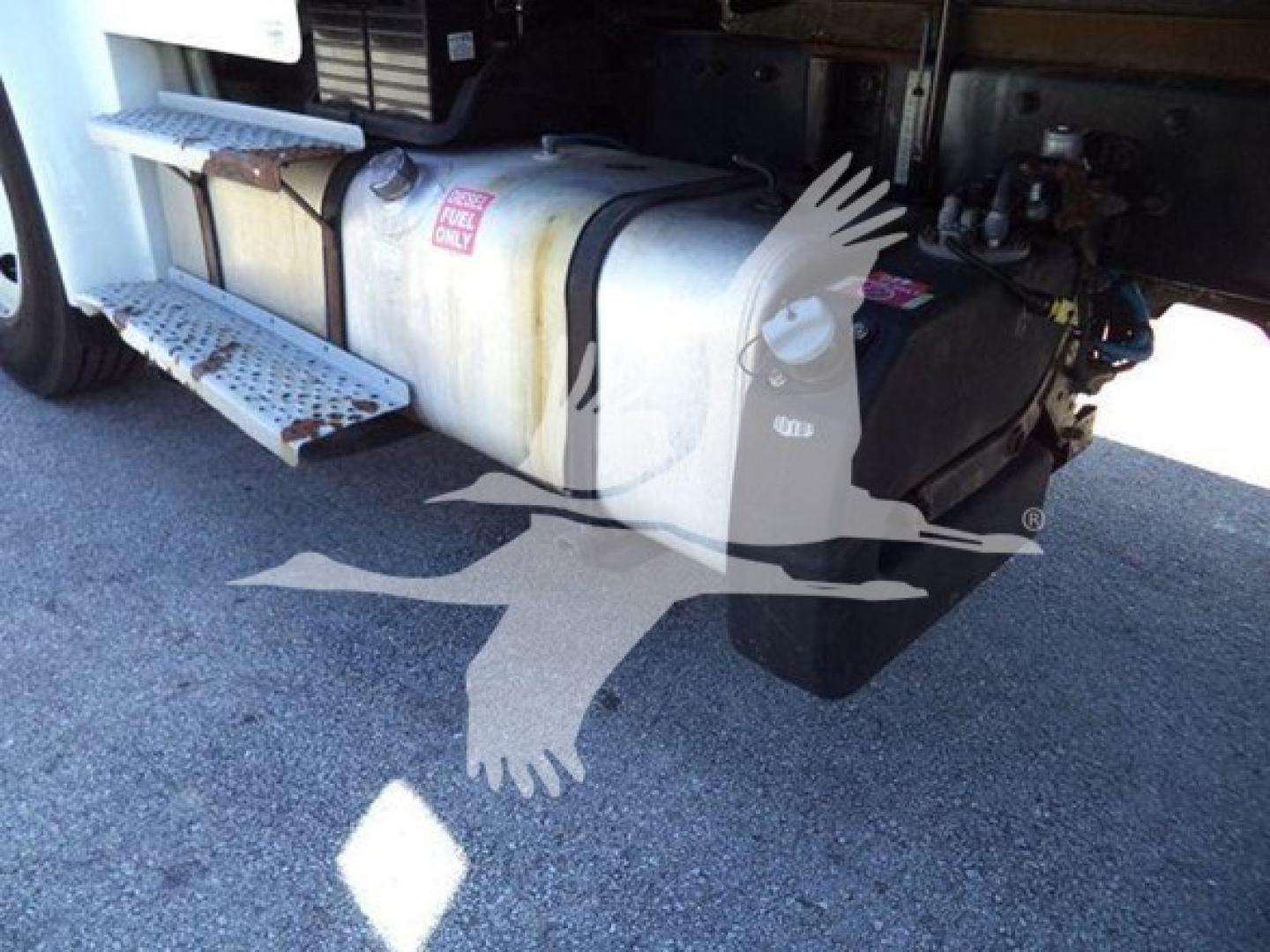 Tank fuel system under Freightliner M2 106 cab; side view with fuel tank, steps, and hoses visible.