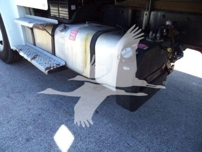 Tank fuel system under Freightliner M2 106 cab; side view with fuel tank, steps, and hoses visible.